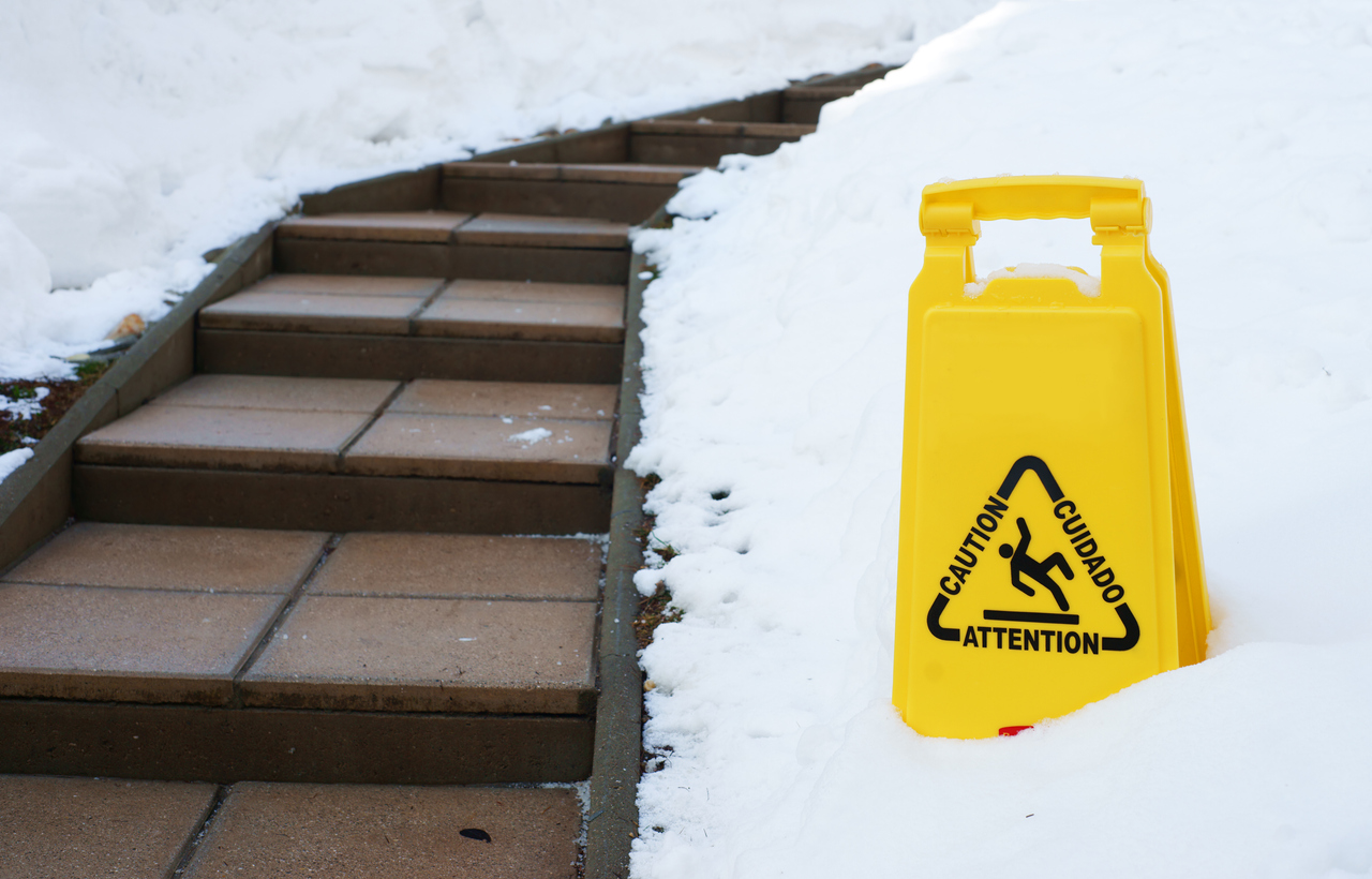 caution sign next to stairs in the snow