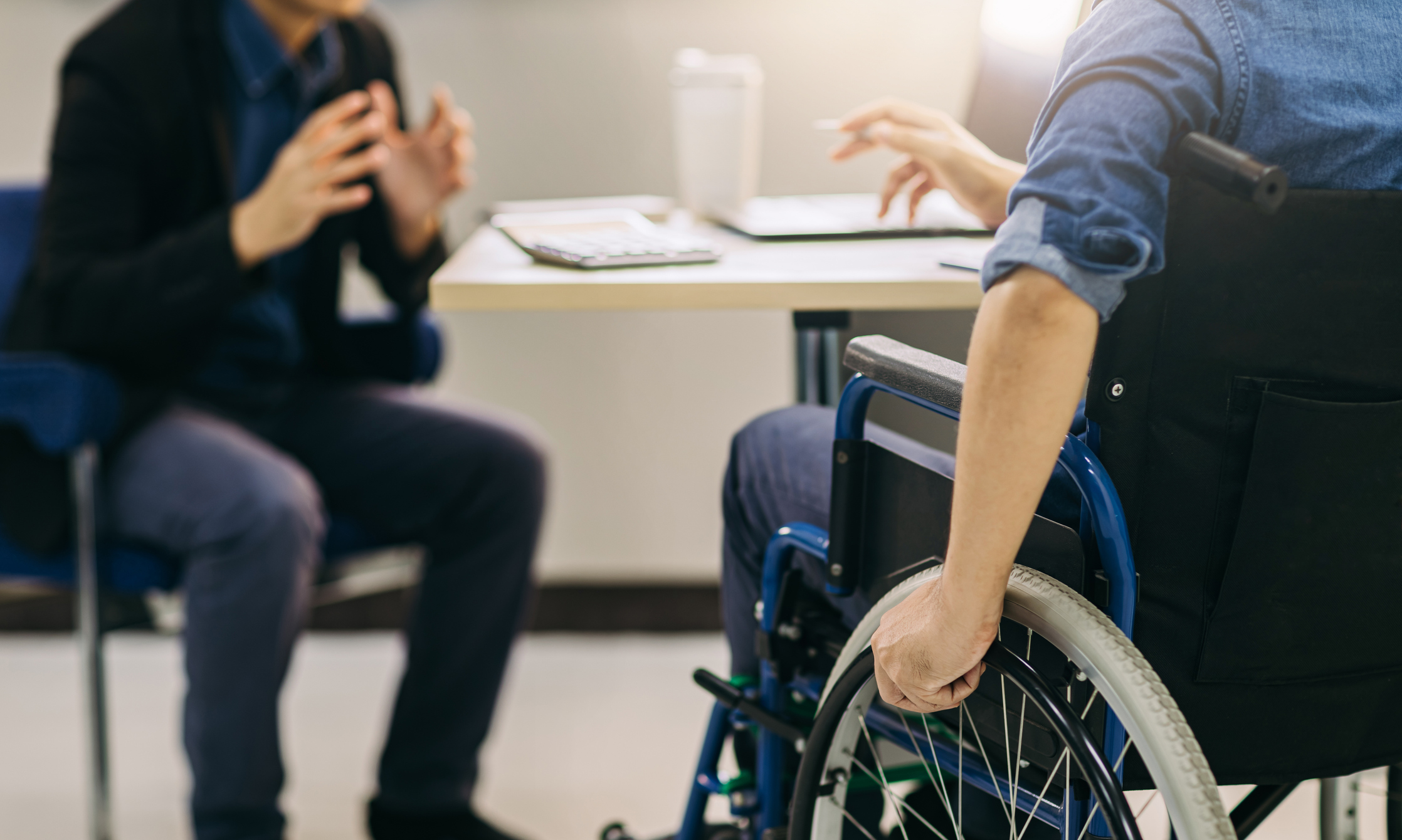 Man Sitting in Wheelchair During a Meeting With Another Man