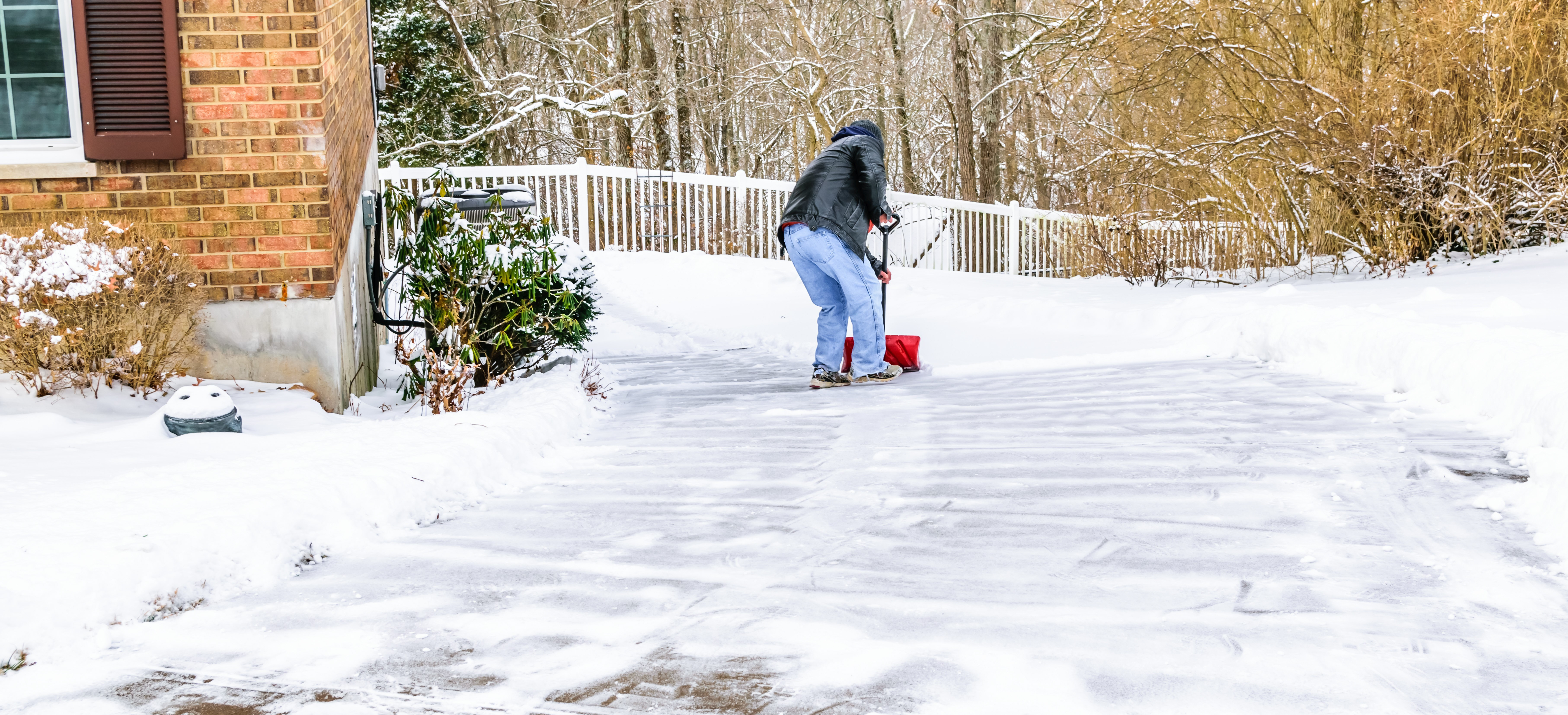 Man shovels snow in a driveway