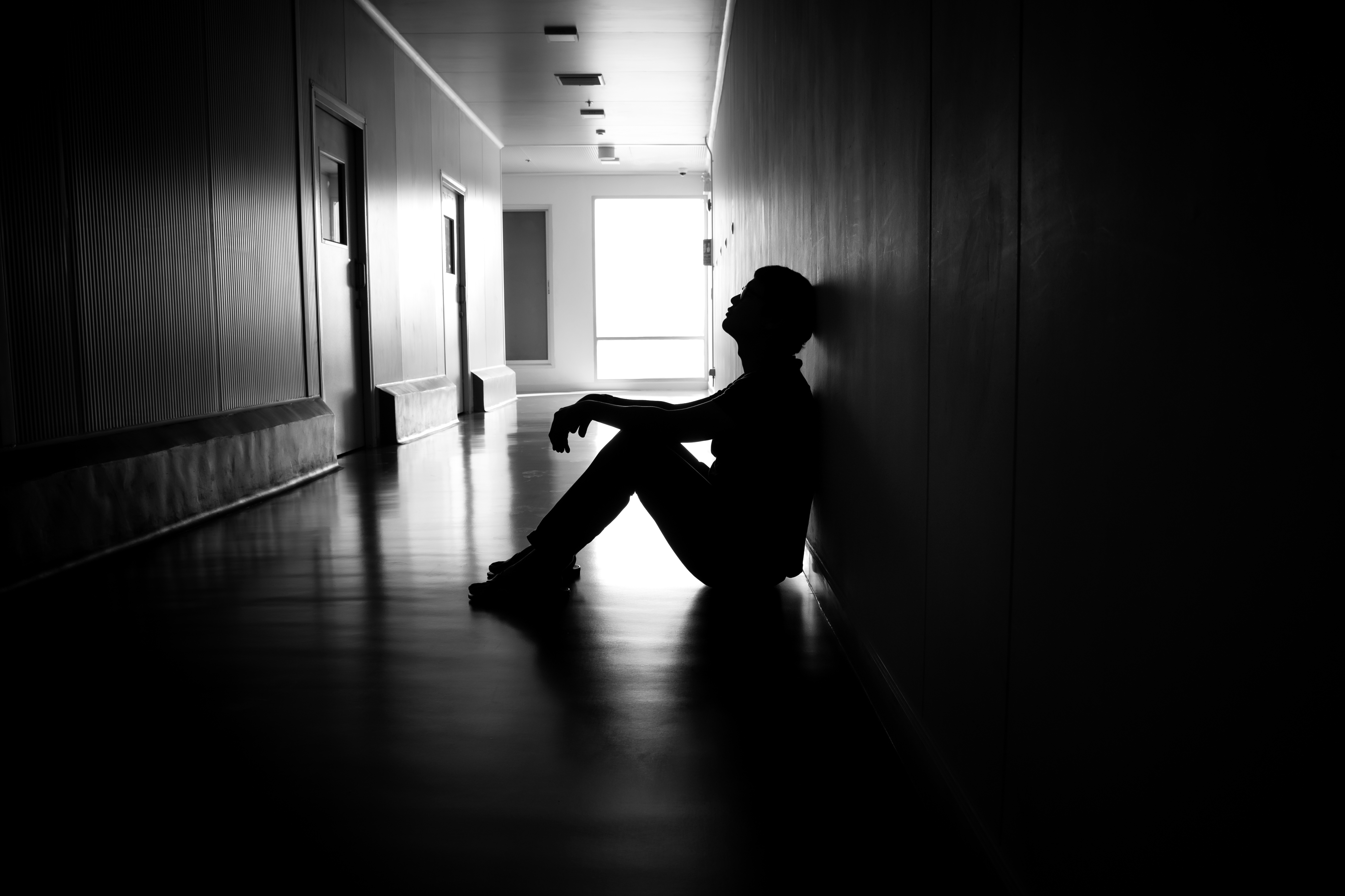man alone sitting in hallway