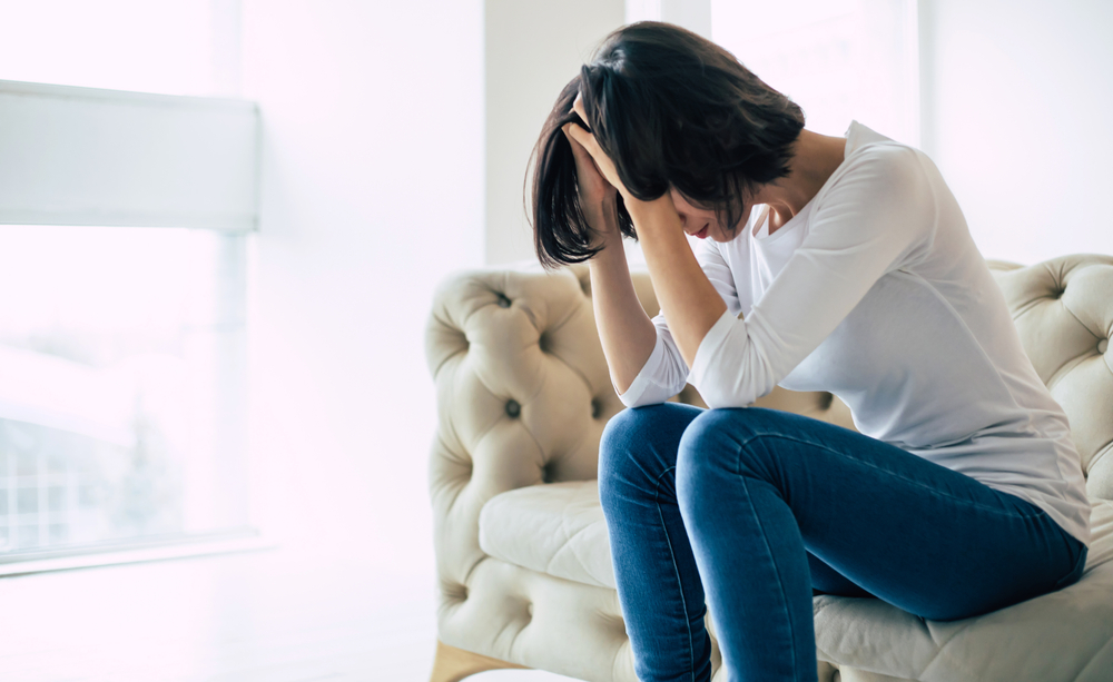 Woman sitting on couch upset